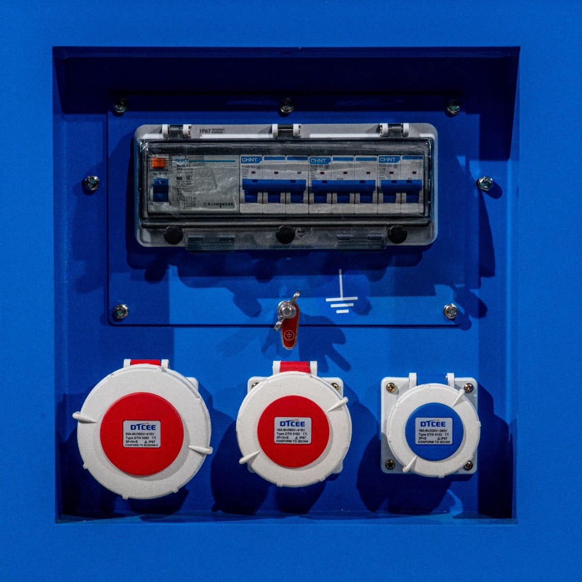 RX-16/20 Stage III Stromgenerator mit blauem Gehäuse, sichtbarem Sicherungskasten und drei roten Steckdosen. Schalter und Erdungssymbol sind ebenfalls abgebilde
